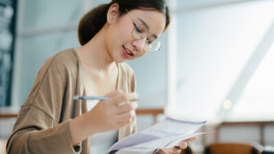 A young woman filling out paperwork.