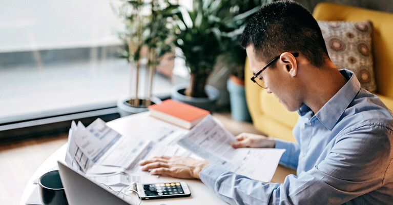 A man making calculations on his phone calculator app.