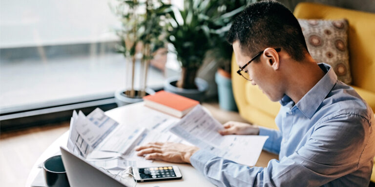 A man making calculations on his phone calculator app.
