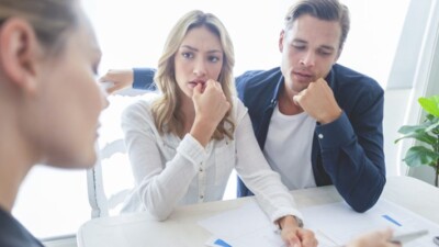 Woman and man looking at concerned as they go over paperwork.