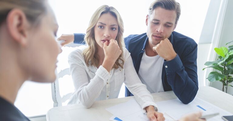 Woman and man looking at concerned as they go over paperwork.