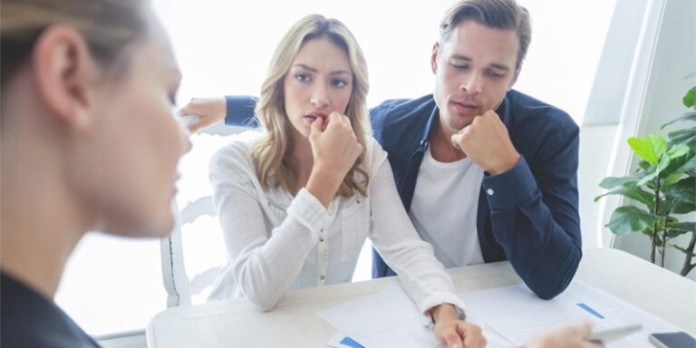Woman and man looking at concerned as they go over paperwork.