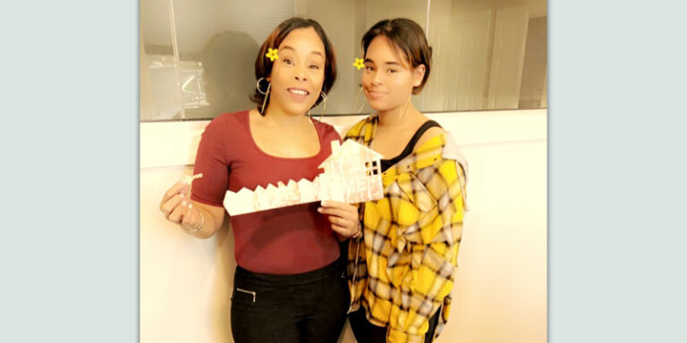 A mother and daughter holding their new house keys.