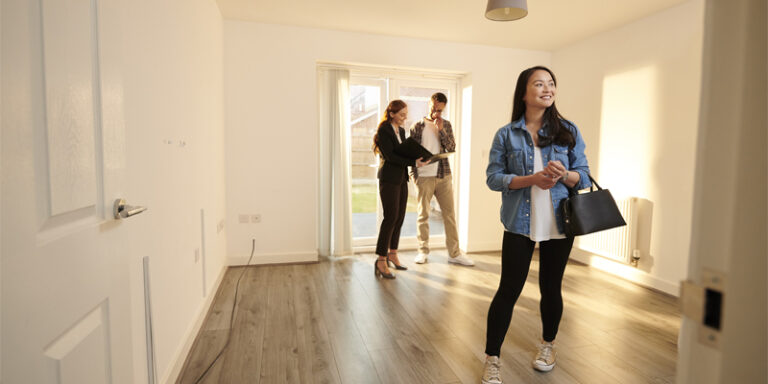 A real estate agent showing a house to a couple.