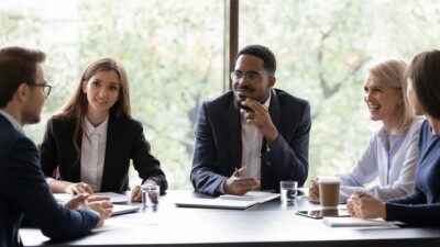 Businesspeople smiling at a meeting.