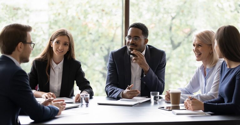 Businesspeople smiling at a meeting.