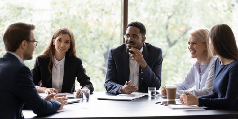 Businesspeople smiling at a meeting.