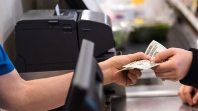 Cashier accepting cash payment from a customer.