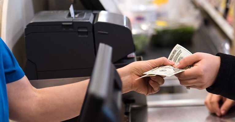 Cashier accepting cash payment from a customer.