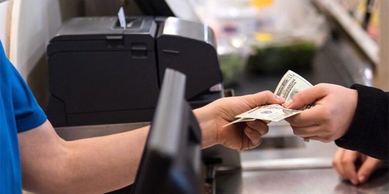 Cashier accepting cash payment from a customer.