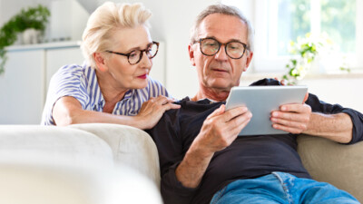 A man and a woman looking at a tablet.