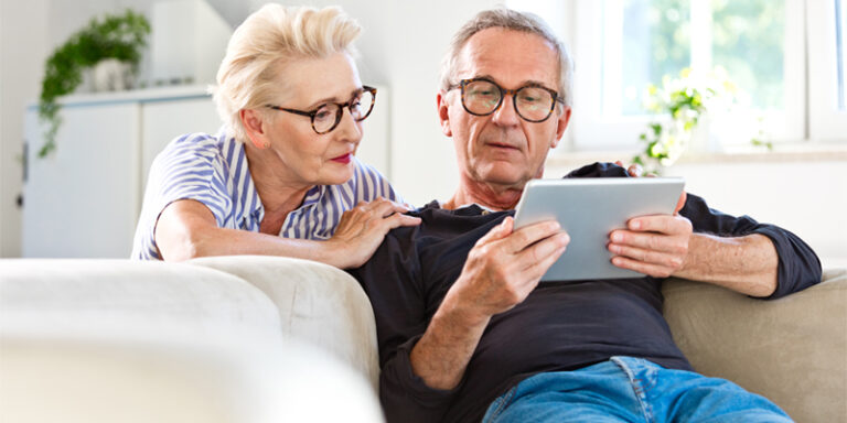 A man and a woman looking at a tablet.
