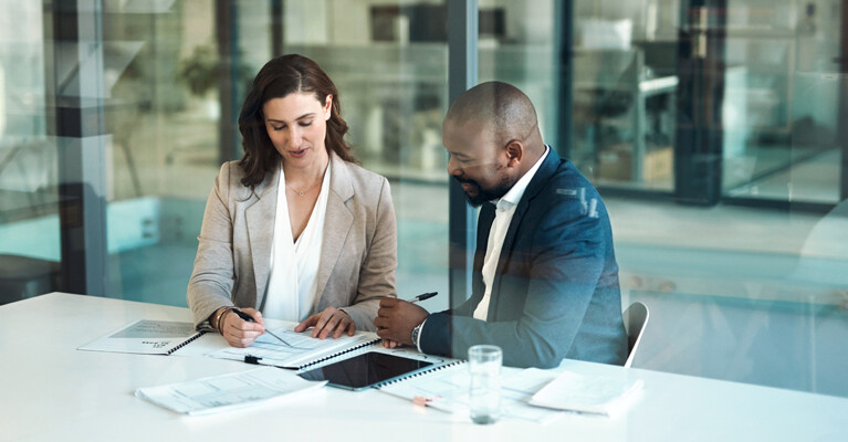 A private banker reviewing mortgage documents with their client.