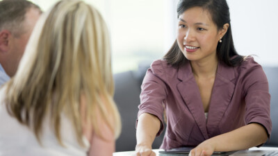 A banker reviewing paperwork with a man and a woman.