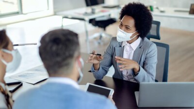 Businesswoman speaking with man and woman.