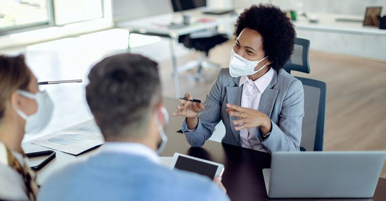 Businesswoman speaking with man and woman.