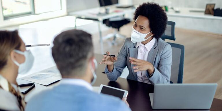 Businesswoman speaking with man and woman.