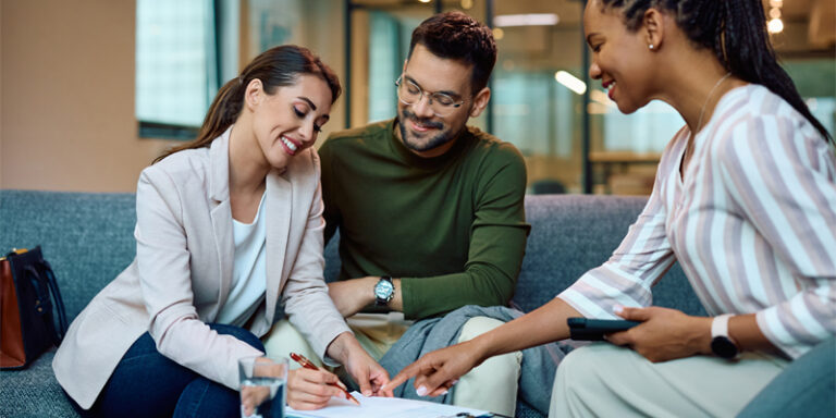 A couple filling out paperwork with a banker.