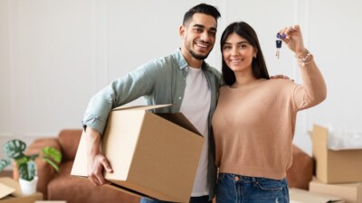 New home owners holding house keys and a moving box.