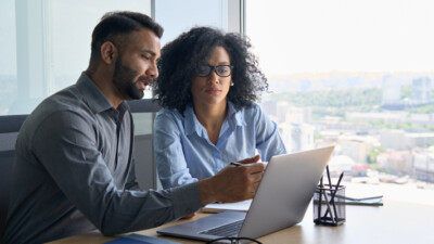 Two businesspeople looking at a laptop.