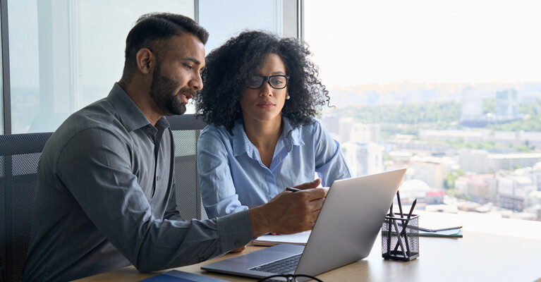 Two businesspeople looking at a laptop.