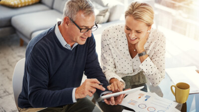 A couple looking at information on a tablet.