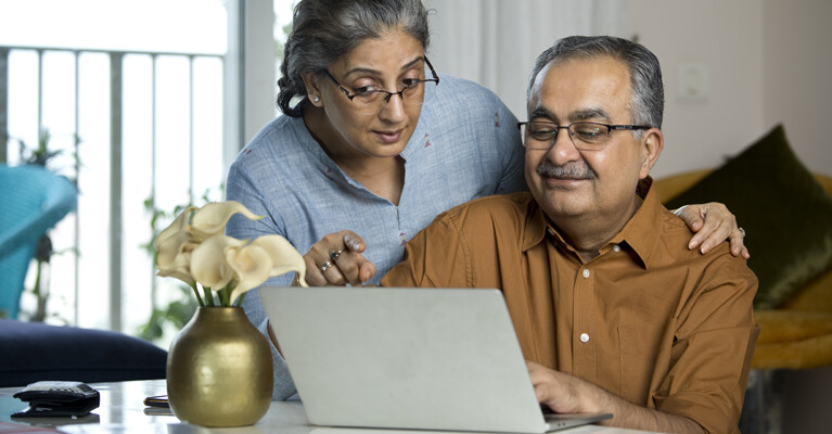 A couple looking at a laptop.