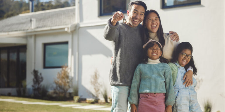 A family in front of their new home.