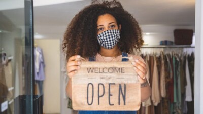 Small business owner holding an "Open" sign.