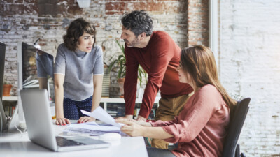 A group of employees from a small business discussing ways to drive revenue.