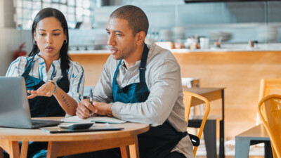 Small business owners discussing business expenses.