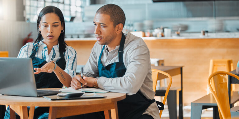 Small business owners discussing business expenses.
