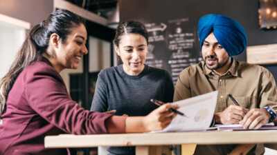 A businesswoman reviewing documents with a couple.