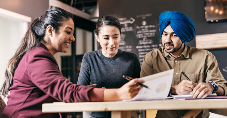 A businesswoman reviewing documents with a couple.
