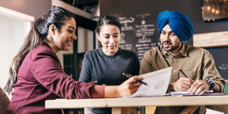 A businesswoman reviewing documents with a couple.