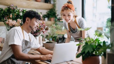 Small business owners smiling at laptop.