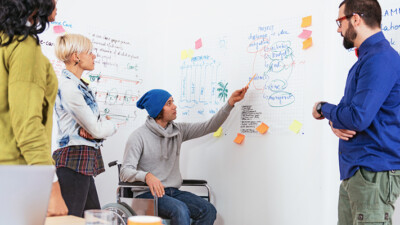 Workers using a whiteboard to brainstorm.