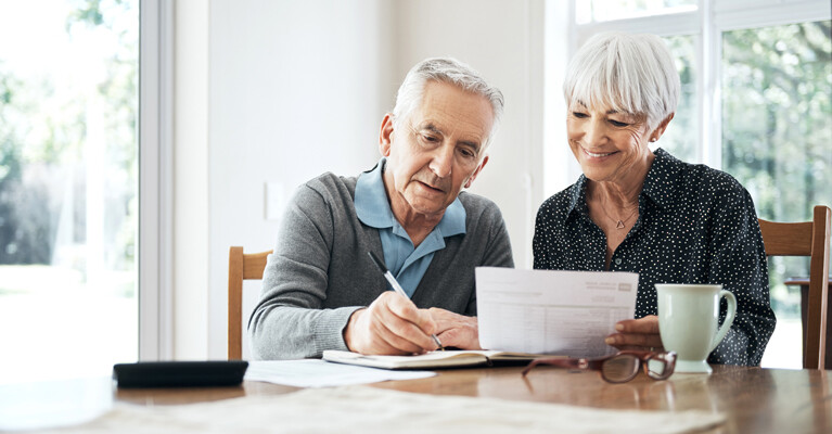 An elderly couple working on their finances.