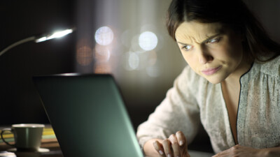 A woman looking skeptically at her computer.