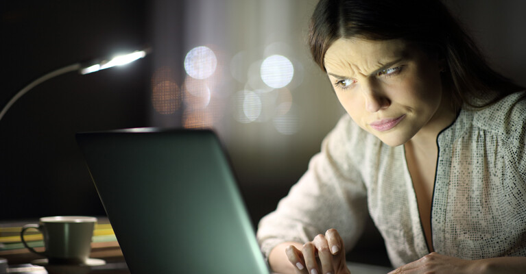 A woman looking skeptically at her computer.