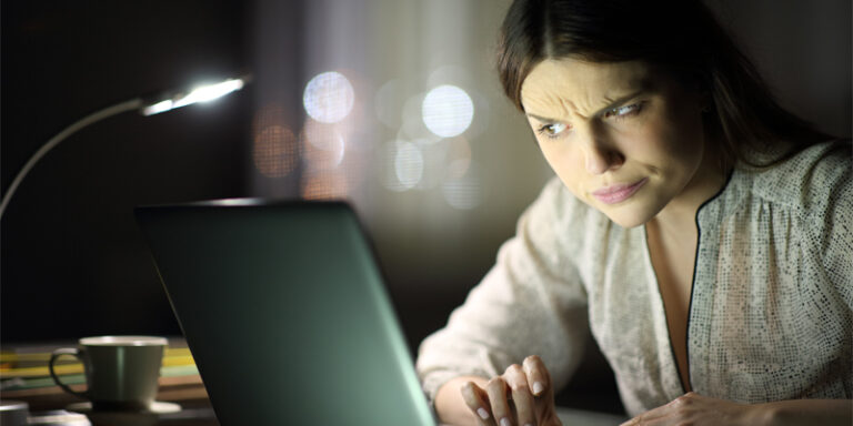 A woman looking skeptically at her computer.