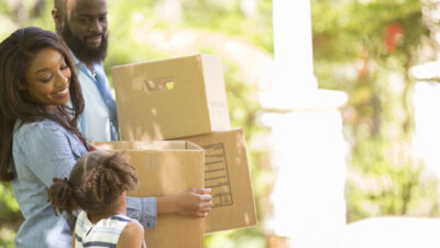 Three family members moving boxes.