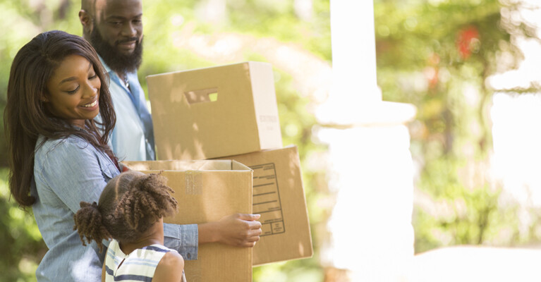 Three family members moving boxes.