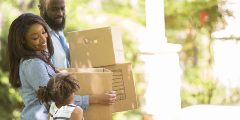 Three family members moving boxes.