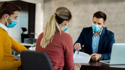 A banker reviewing a document with a man and a woman.