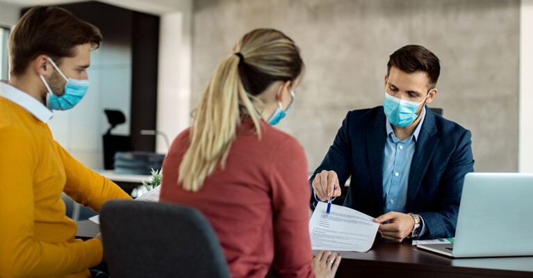 A banker reviewing a document with a man and a woman.