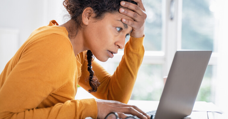 Woman looking intently at a laptop computer.