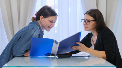 Teenage girl and woman looking at a folder.