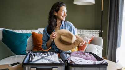 A woman packing a suitcase for vacation.