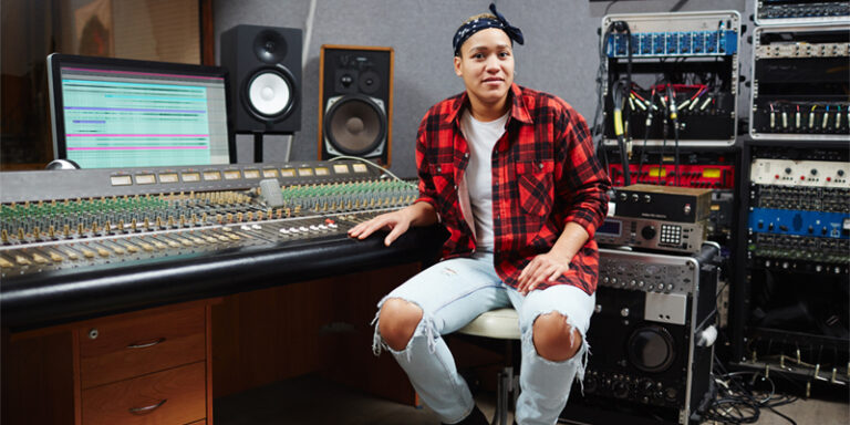 A music producer in front of audio equipment.